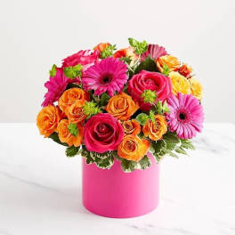 Bouquet of pink, orange, and yellow roses with gerbera daisies in a pink vase