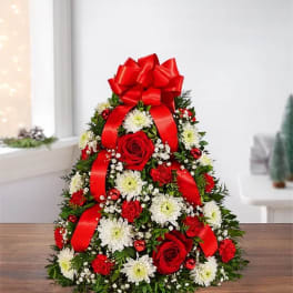 Cone-shaped floral arrangement with red roses, white daisies, and a large red bow