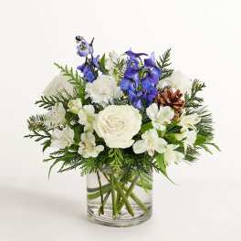 White and blue floral arrangement in a clear glass vase