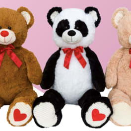 Three teddy bears with red bows sit side by side.