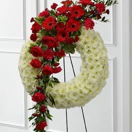 Red and white floral funeral wreath on a stand