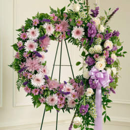 Large floral wreath on an easel with pink, purple, and white flowers
