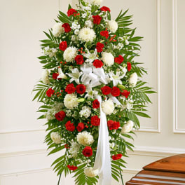 Standing floral spray with red and white flowers and a white ribbon