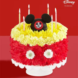 Mickey Mouse-themed flower cake with candles on a white stand