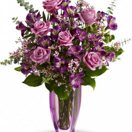 Purple roses and alstroemeria in a tall purple glass vase
