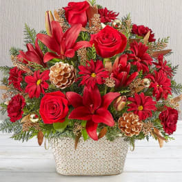 Red roses and lilies in a decorative white container