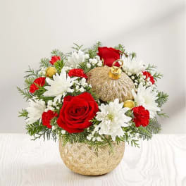 Red roses and white daisies arranged in a gold ornament-shaped vase