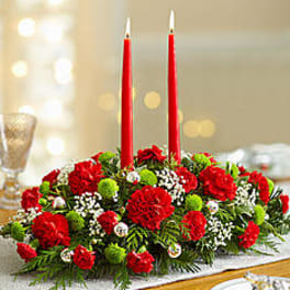 Low red floral centerpiece with two tall red candles
