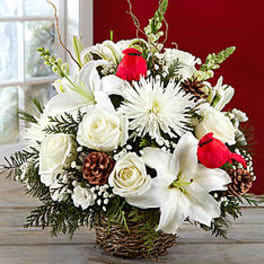 White floral arrangement with lilies and roses in a wicker basket