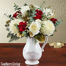 Bouquet of red and white flowers in a white pitcher vase
