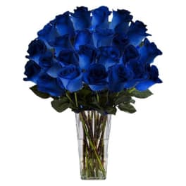 Blue roses arranged in a clear glass vase