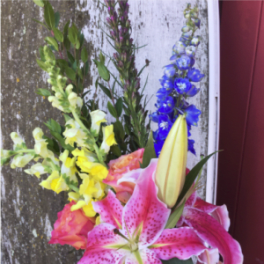 Bouquet with pink lilies, yellow snapdragons, and blue delphinium
