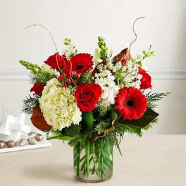 Red roses and gerbera daisies in a glass vase