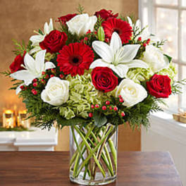 Red and white roses with white lilies in a glass vase