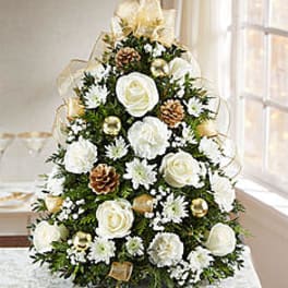 White floral arrangement shaped like a Christmas tree with gold accents
