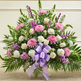 Large pink and white floral spray with a purple ribbon bow