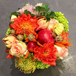 Round bouquet with orange dahlias, pale roses, and decorative gourds