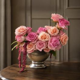 Pink and peach roses arranged in a silver vase