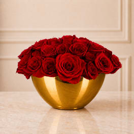Red roses arranged in a gold bowl vase