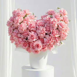 Heart-shaped bouquet of pink roses in a white vase