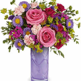 Pink and purple mixed bouquet in a lavender glass vase