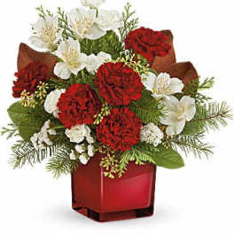 Red carnations and white flowers in a red glass vase