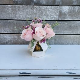 Pink roses arranged in a white geometric vase