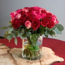 Bouquet of red and pink roses in a clear glass vase
