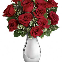 Red roses arranged in a clear glass vase