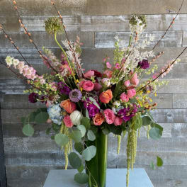 Tall mixed bouquet in a glass vase with pink, peach, and white flowers