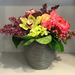 Colorful mixed flower arrangement in a gray pot