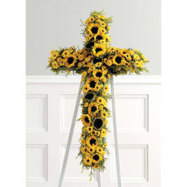 Tall cross-shaped standing spray of yellow sunflowers and daisies on a metal easel