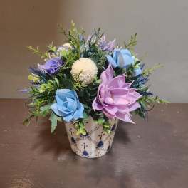 Mixed artificial flowers in a patterned ceramic pot