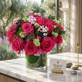 Pink rose bouquet in a clear glass vase with small pale pink filler flowers