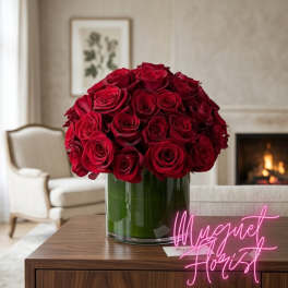Red rose bouquet in a clear glass vase on a table