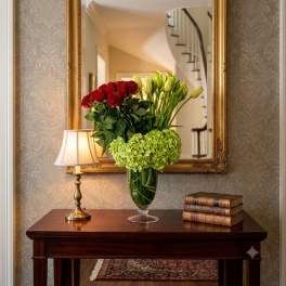 Red roses and green hydrangeas in a glass vase on a table