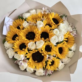 Bouquet of sunflowers, white roses, and pale pink alstroemeria in tan wrap