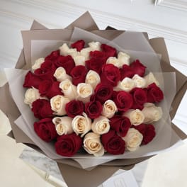 Bouquet of red and cream roses wrapped in brown and translucent paper
