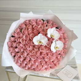 Large bouquet of pink roses with three white orchids