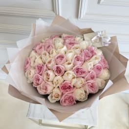 Large bouquet of pink and cream roses wrapped in blush paper
