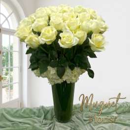 Tall vase arrangement of pale yellow roses with white flowers