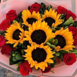 Bouquet of sunflowers and red roses wrapped in pink paper