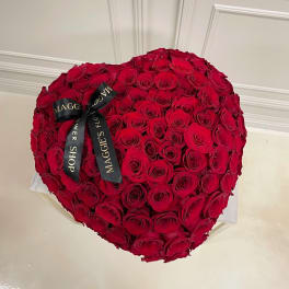 Heart-shaped bouquet of red roses with a black ribbon