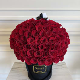 Large bouquet of red roses in a black hatbox