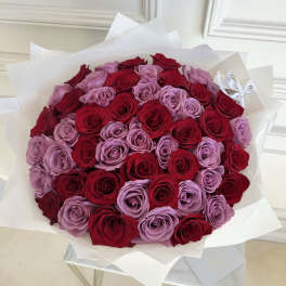 Bouquet of red and lavender roses wrapped in white paper