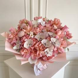 Large pink bouquet with roses and orchids wrapped in pastel paper