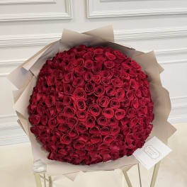 Large bouquet of red roses wrapped in beige paper