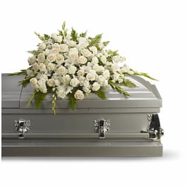 White floral spray on a gray casket