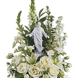 White floral arrangement with a religious statue centerpiece