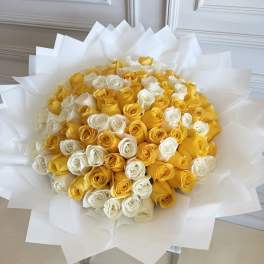 Bouquet of yellow and white roses wrapped in white paper